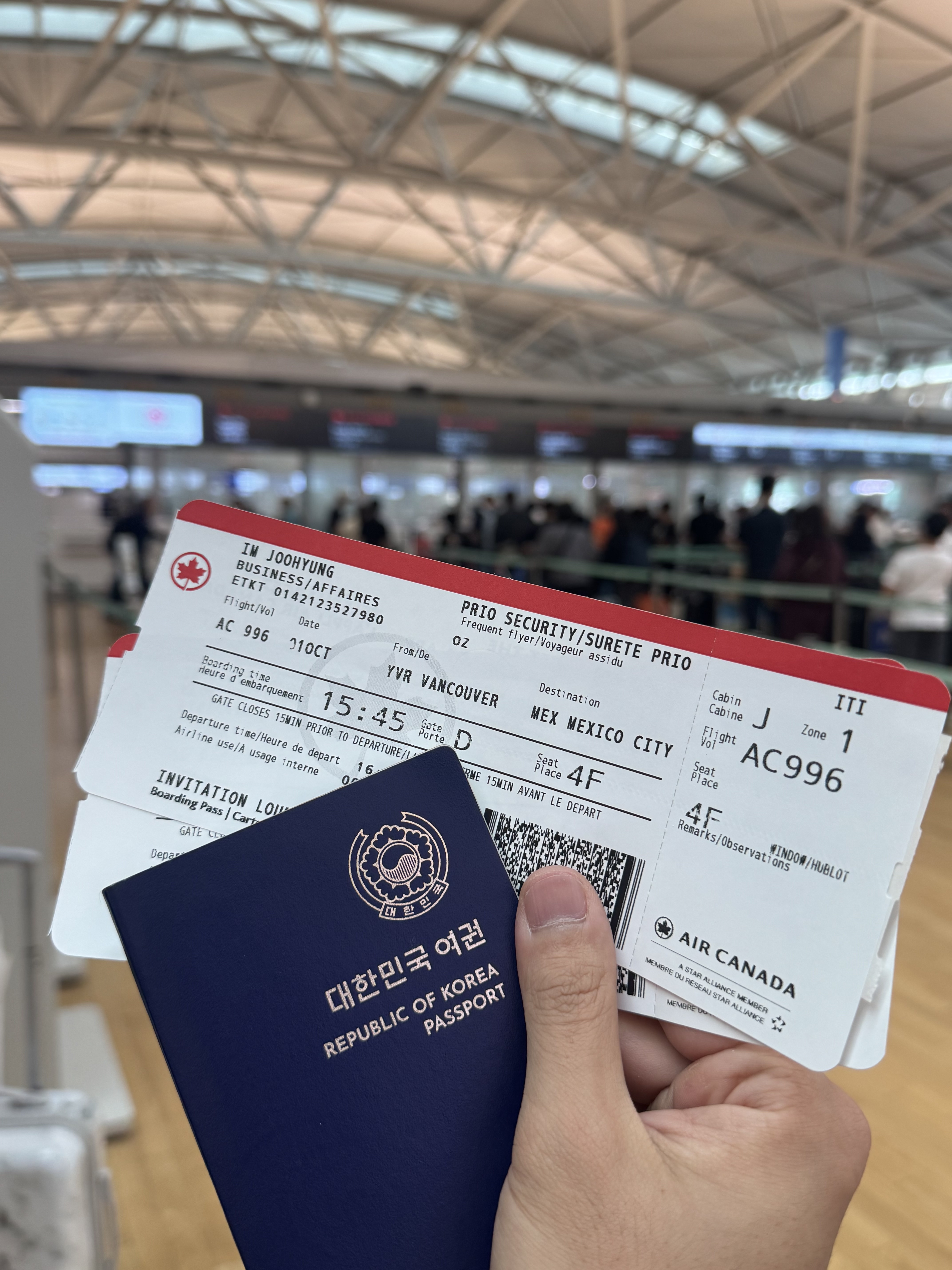 Un viajero sosteniendo su pasaporte y tarjeta de embarque de Air Canada en el Aeropuerto Internacional de Incheon